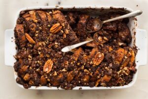 chocolate pecan french toast casserole in baking pan with silver spoons