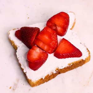 Opened sandwich showing strawberry flower cut out pattern on inside of sandwich.