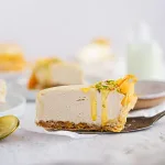 Baklava vanilla honey pistachio cheesecake sliced on white plates on neutral background