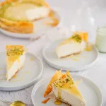 Baklava vanilla honey pistachio cheesecake sliced on white plates on neutral background