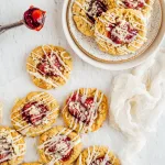 Cookies with Fruit topping and icing on neutral background with gauzy napkin